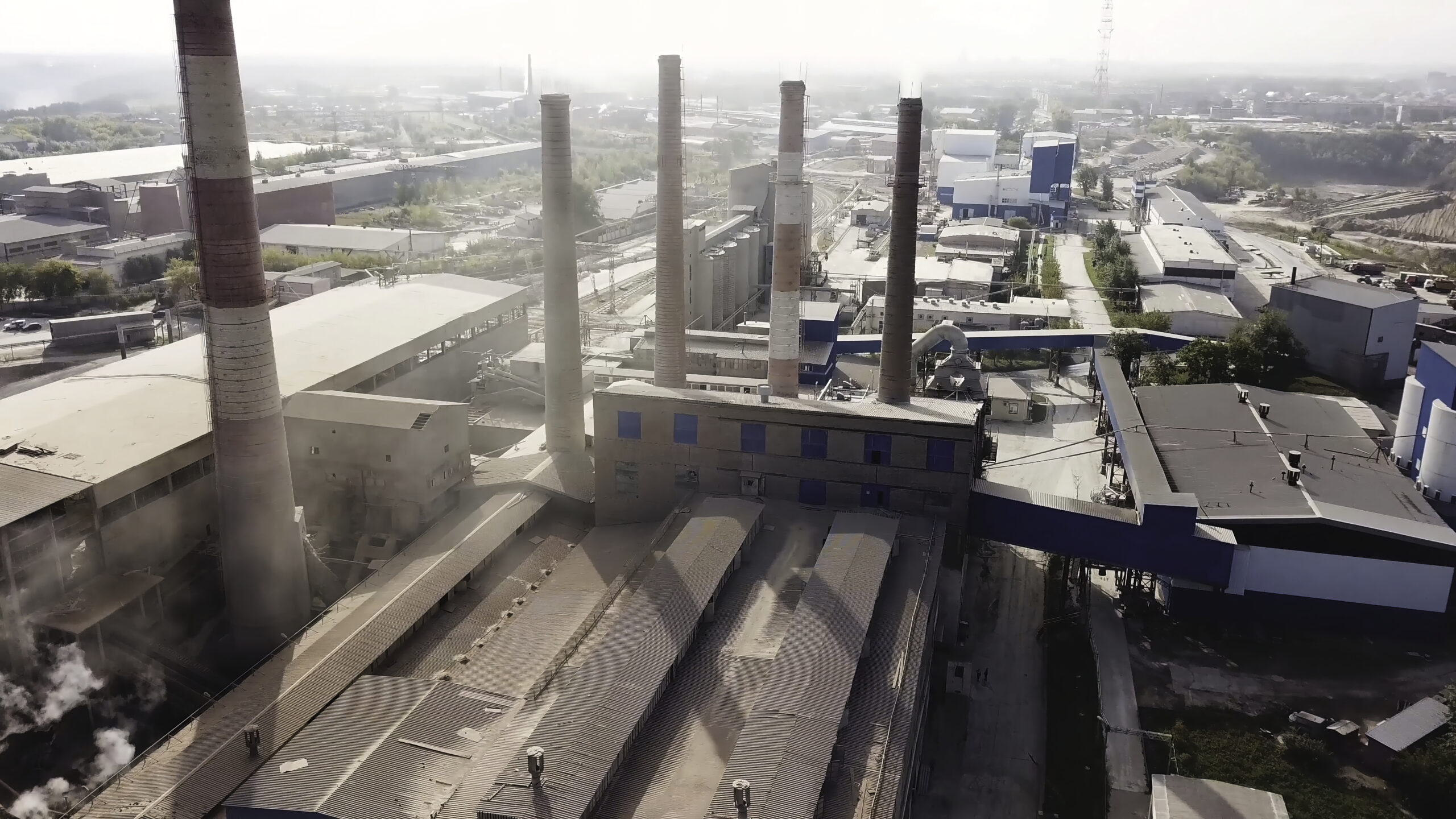 Aerial view of metallurgical production plant. Stock footage. Flying over the factory with the smoke coming from from pipes, bad ecology and air pollution concept.